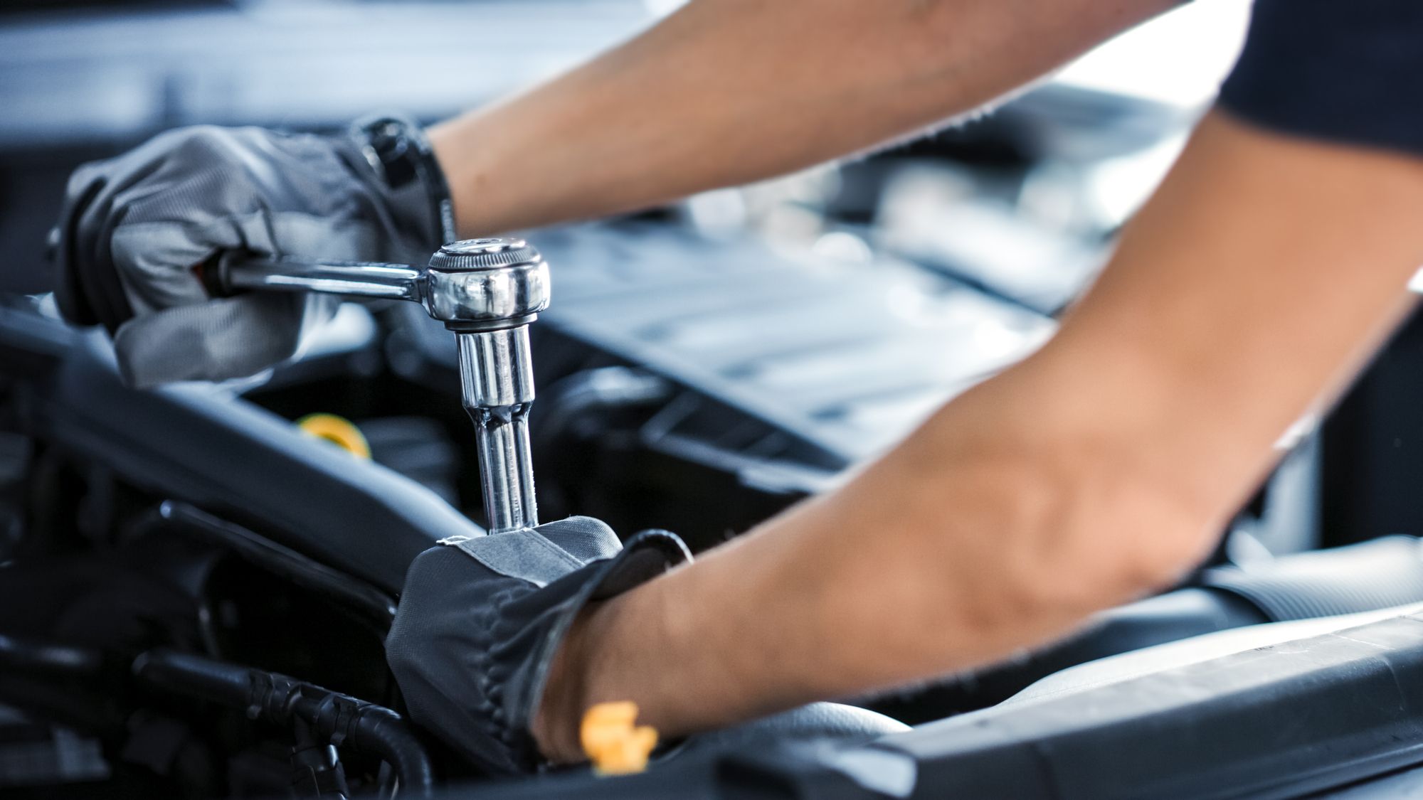 Mechaniker benutzt eine Ratsche im Motorraum